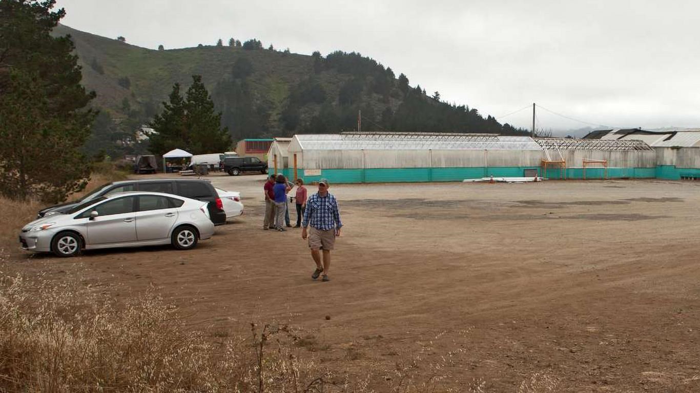 View of the trailhead parking, showing a few visitors and some of the Shelldance Orchid Gardens. 