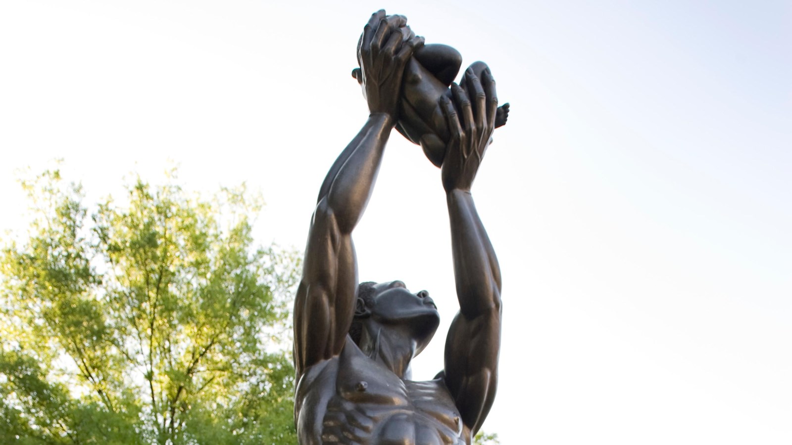 Life size bronze statue of a heroic Father lifting his infant daughter to the heavens