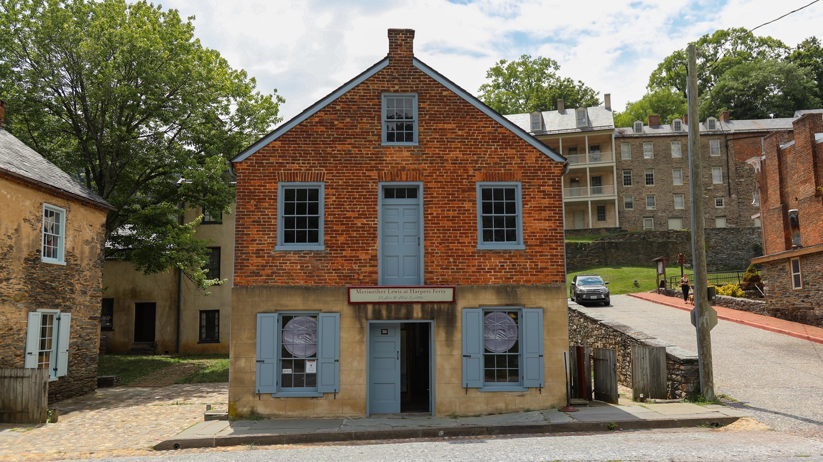 A two story building on a street corner. The upper half is bricked.
