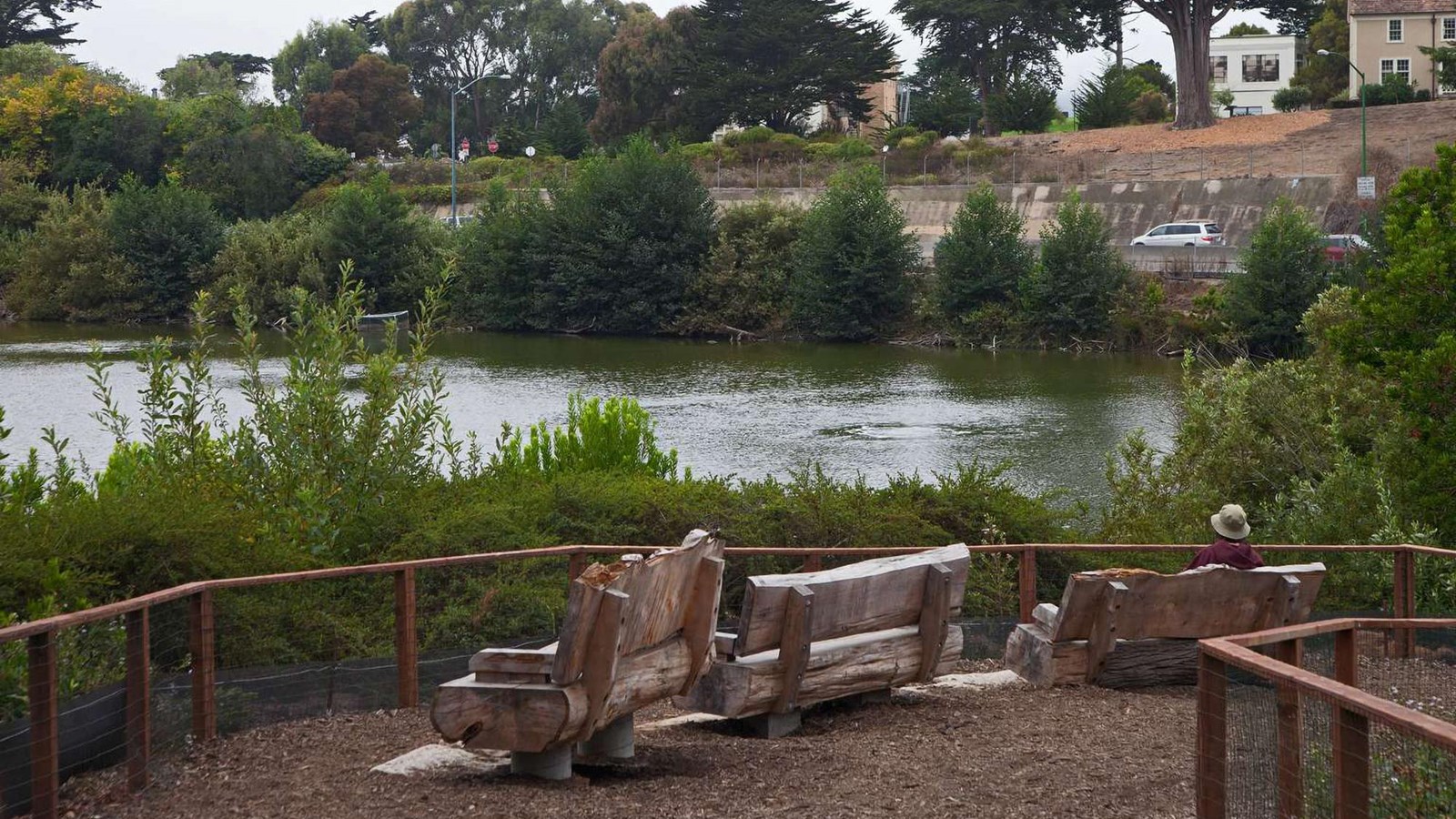 Three wooden benches face out over Mountain Lake. 