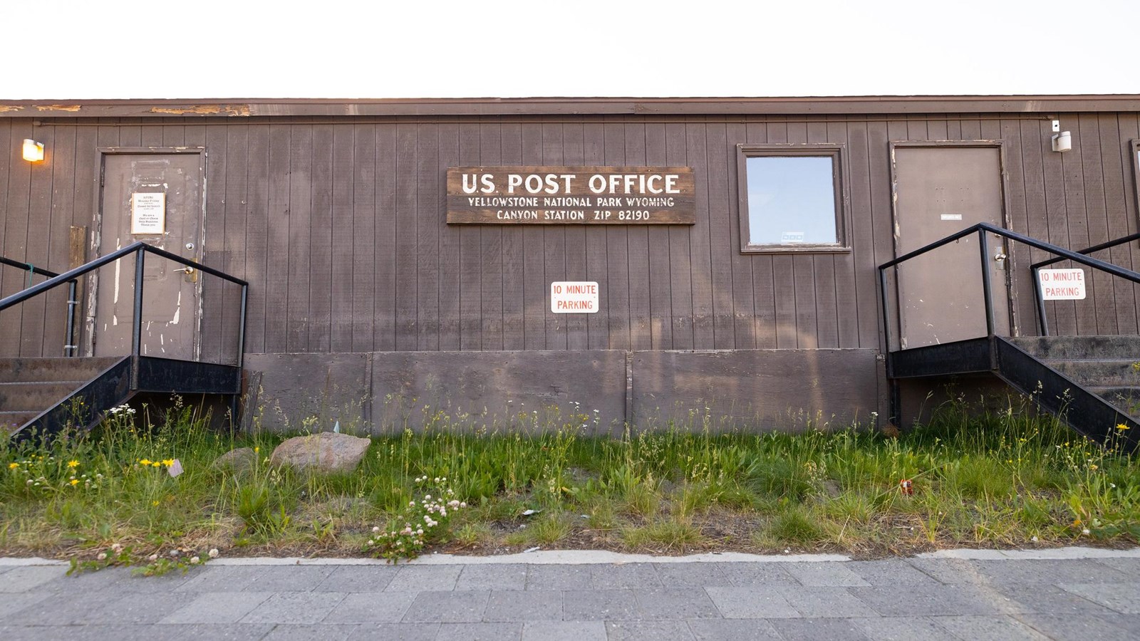 A brown, rectangular mobile building with a sign on the center that says, 