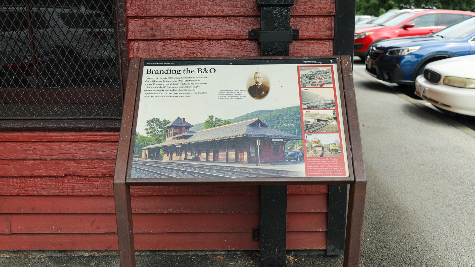 A information panel in front of a red brick building.
