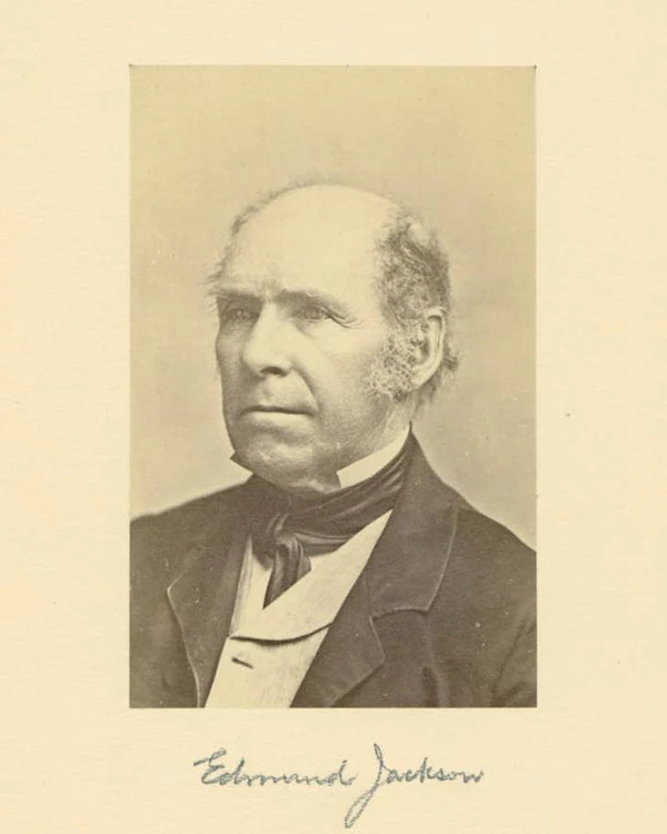 Portrait of a man with sideburns wearing a suit and ascot tie