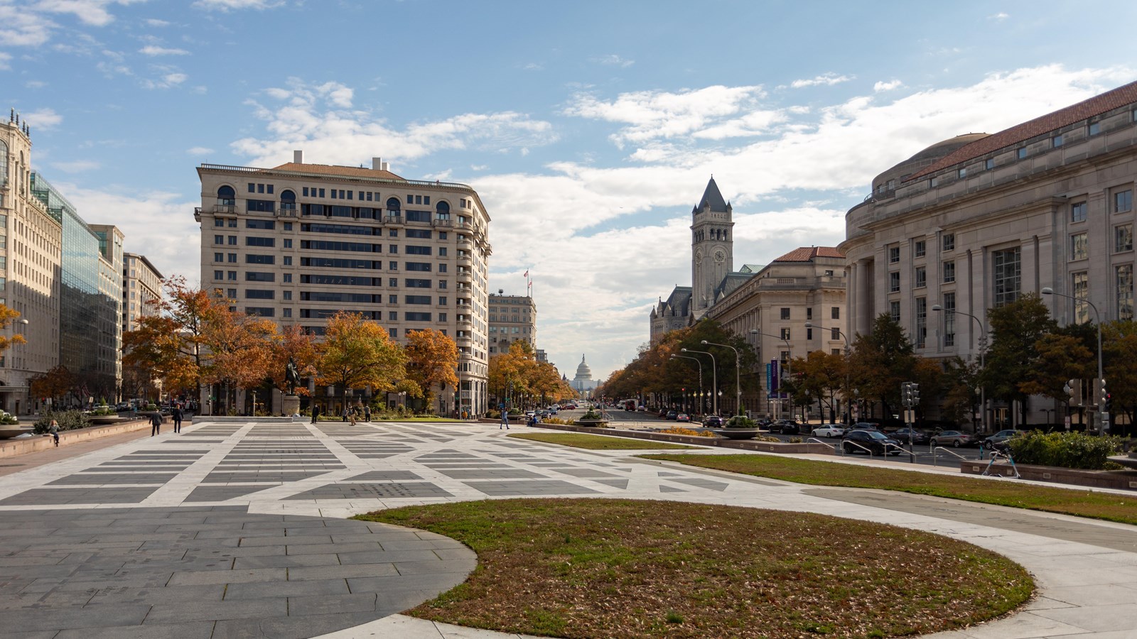 Plaza surrounded by swatches of grass and buildings.