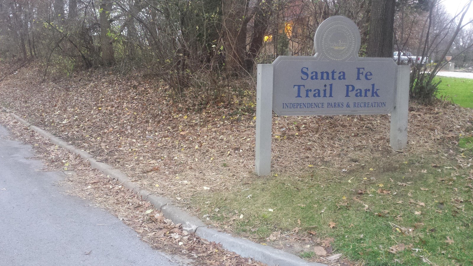 A gray granite sign with blue letters says 