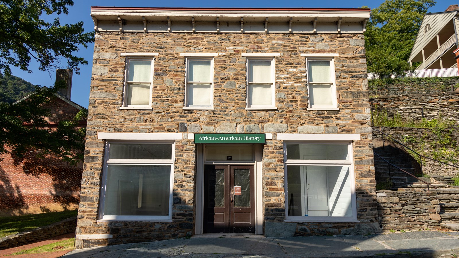 A gray stone building with sign over the door