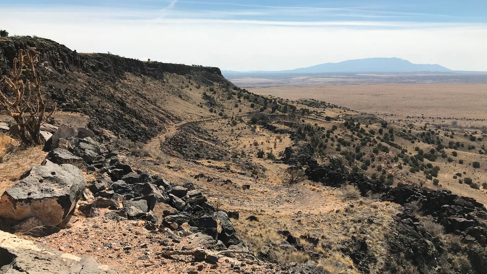 Looking off a steep escarpment onto a rocky desert.