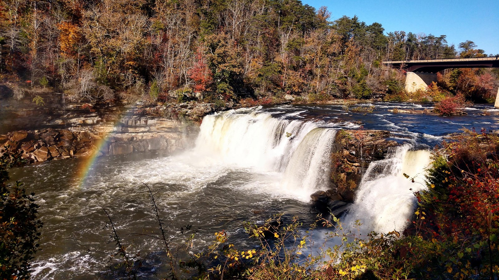 Morning sun produces a rainbow in the mist at Little River Falls in the fall.