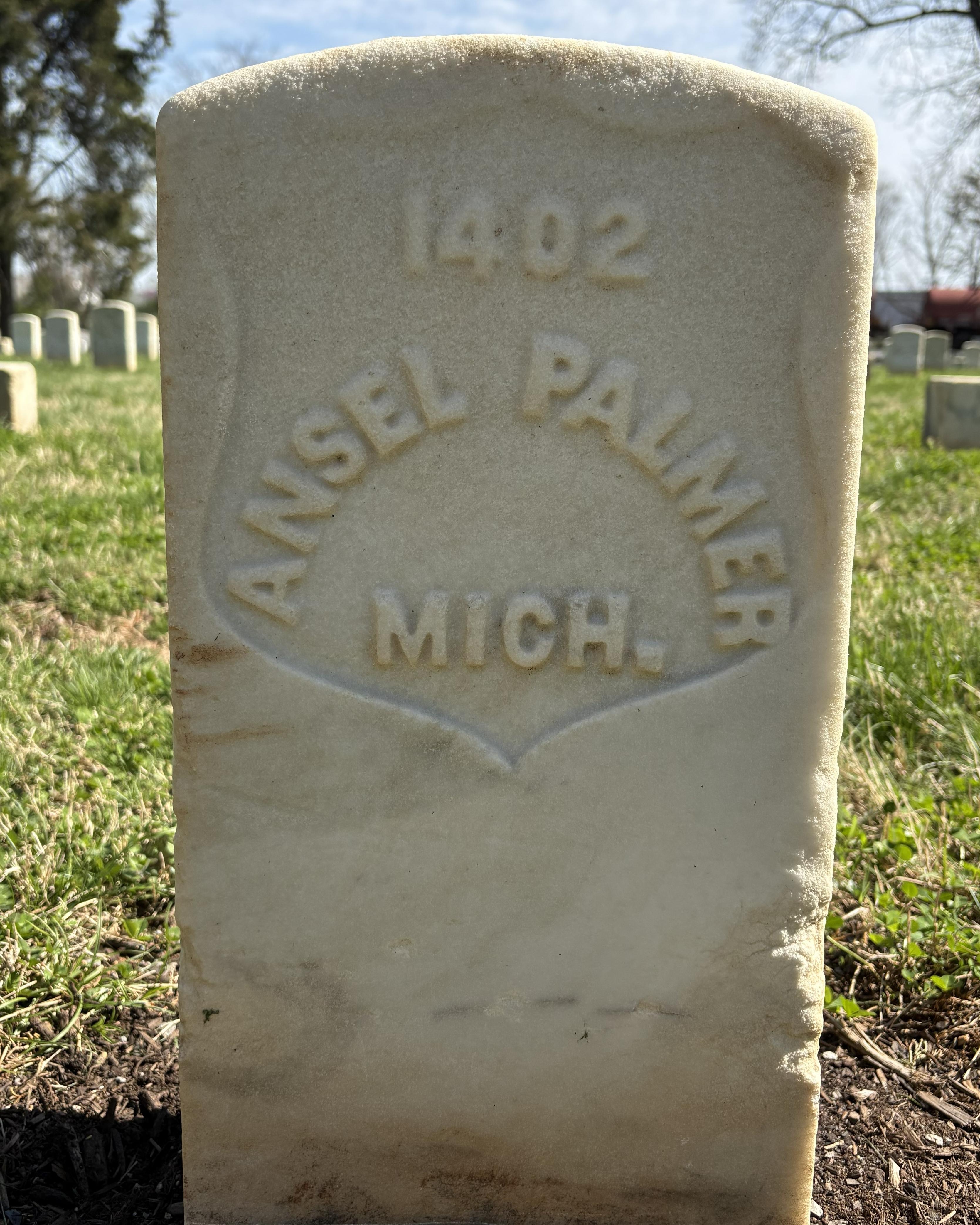 Marble headstone with "Ansel Palmer MICH." inscribed on it. 