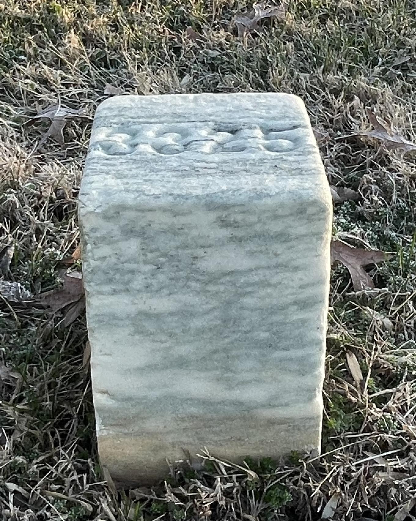 Short, square marble grave marker representing unknown soldiers buried in the cemetery.
