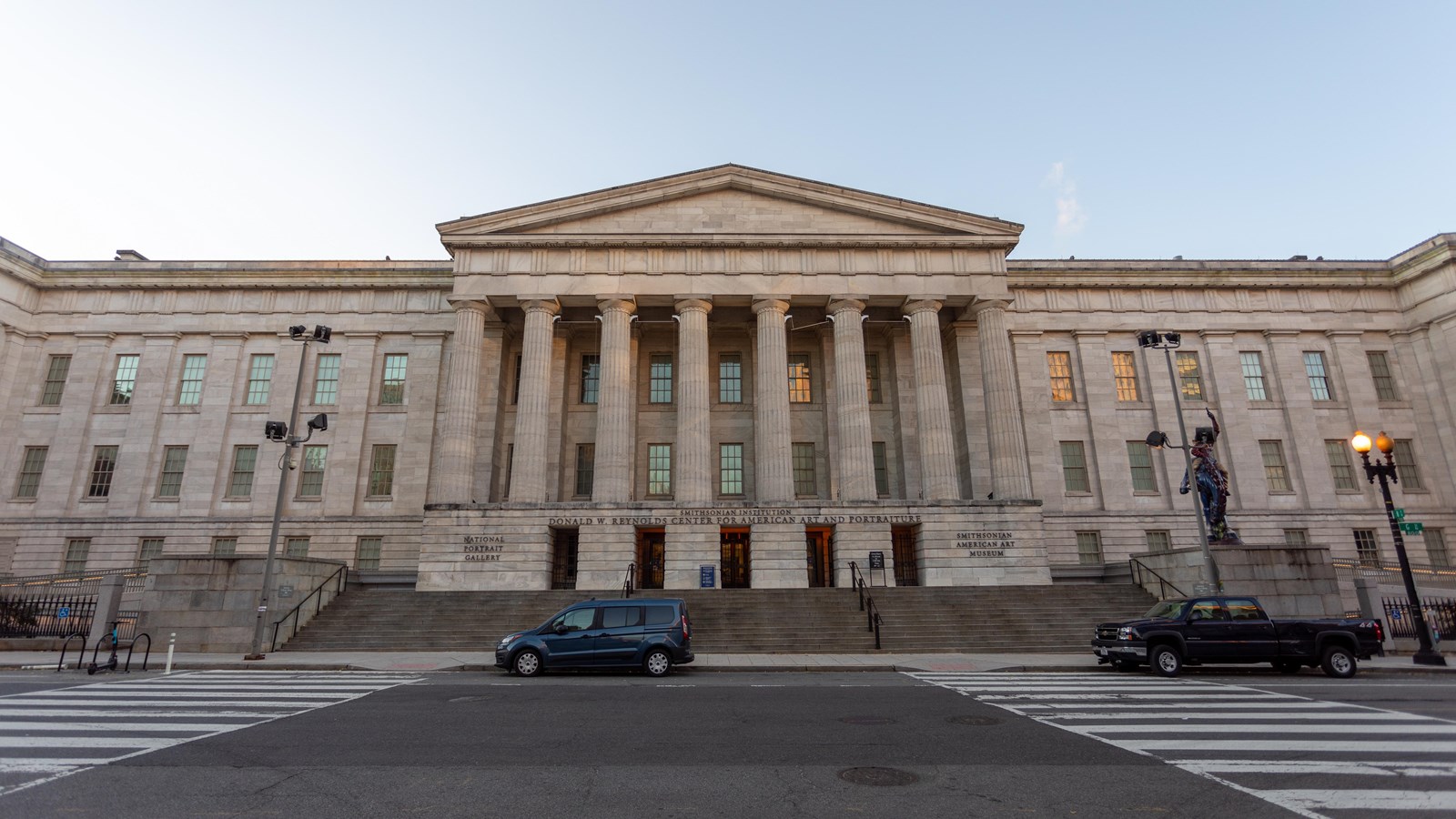 A large stone building with columns at the top of a steep climb of stairs.