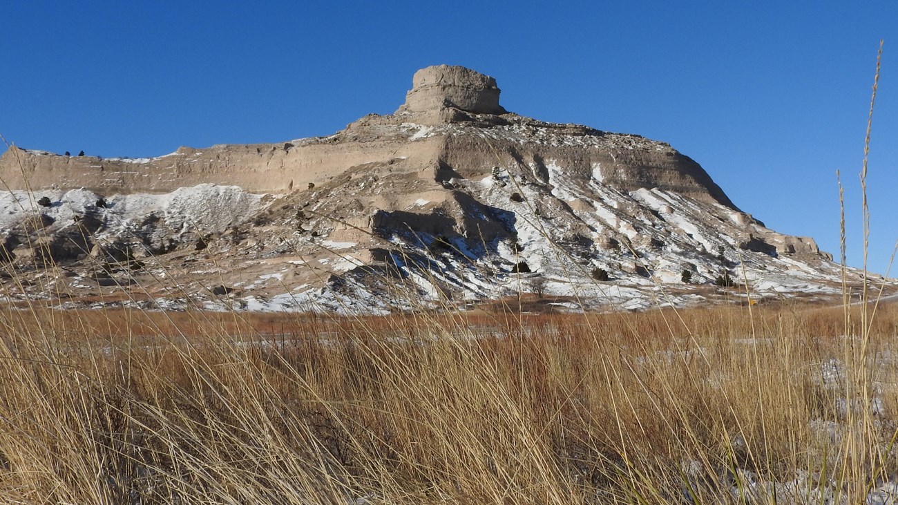 A sandstone bluff is dusted with snow. 