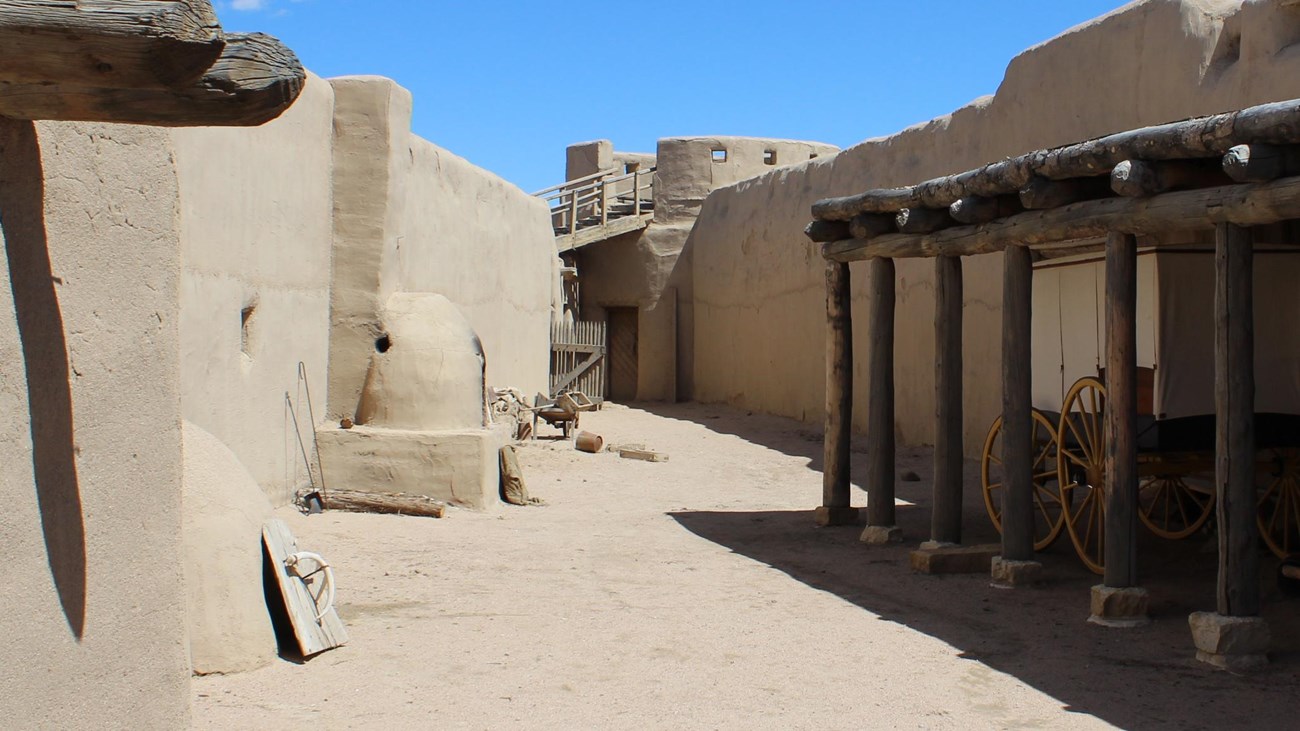 A triangular corral defined by tall adobe walls. 