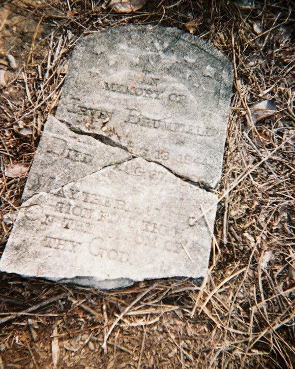 Broken headstone on the ground