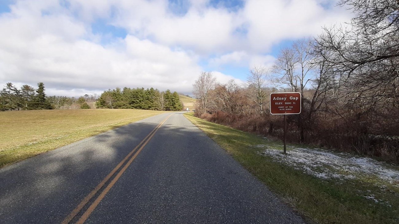 View of the parkway at Adney Gap.  Sign reads, Adney Gap ELEV. 2960 ft. Crest of the Blue Ridge
