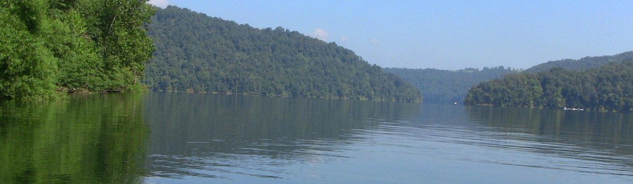view of lake with trees on all sides from cockpit of a kayak 