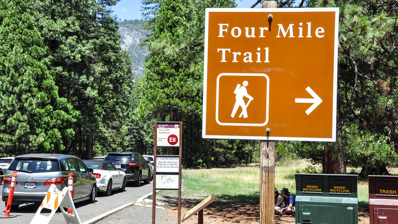 Trailhead sign with bus stop information in background