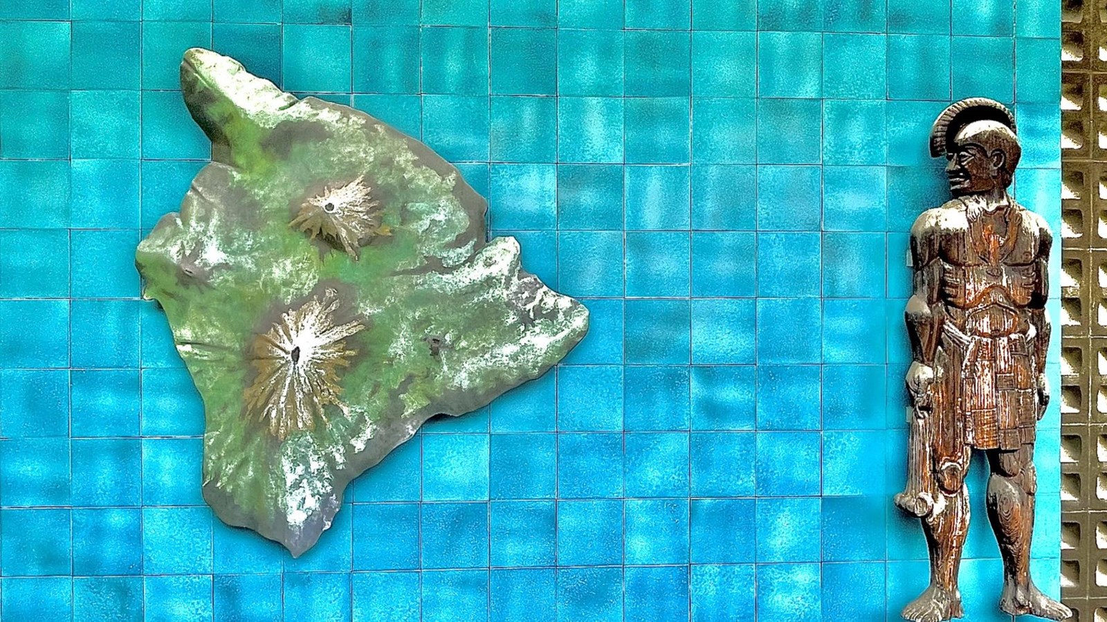Map relief of Hawaii island showing its mountains.  Carving of helmeted Hawaiian warrior.