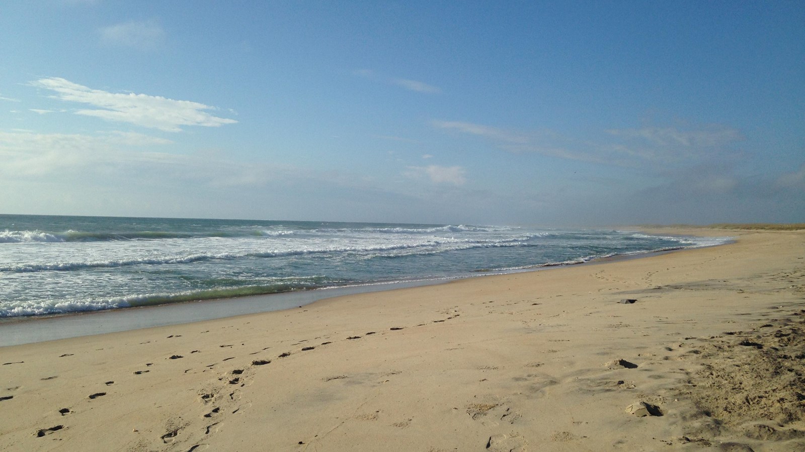 blue waves crashing on sandy beach