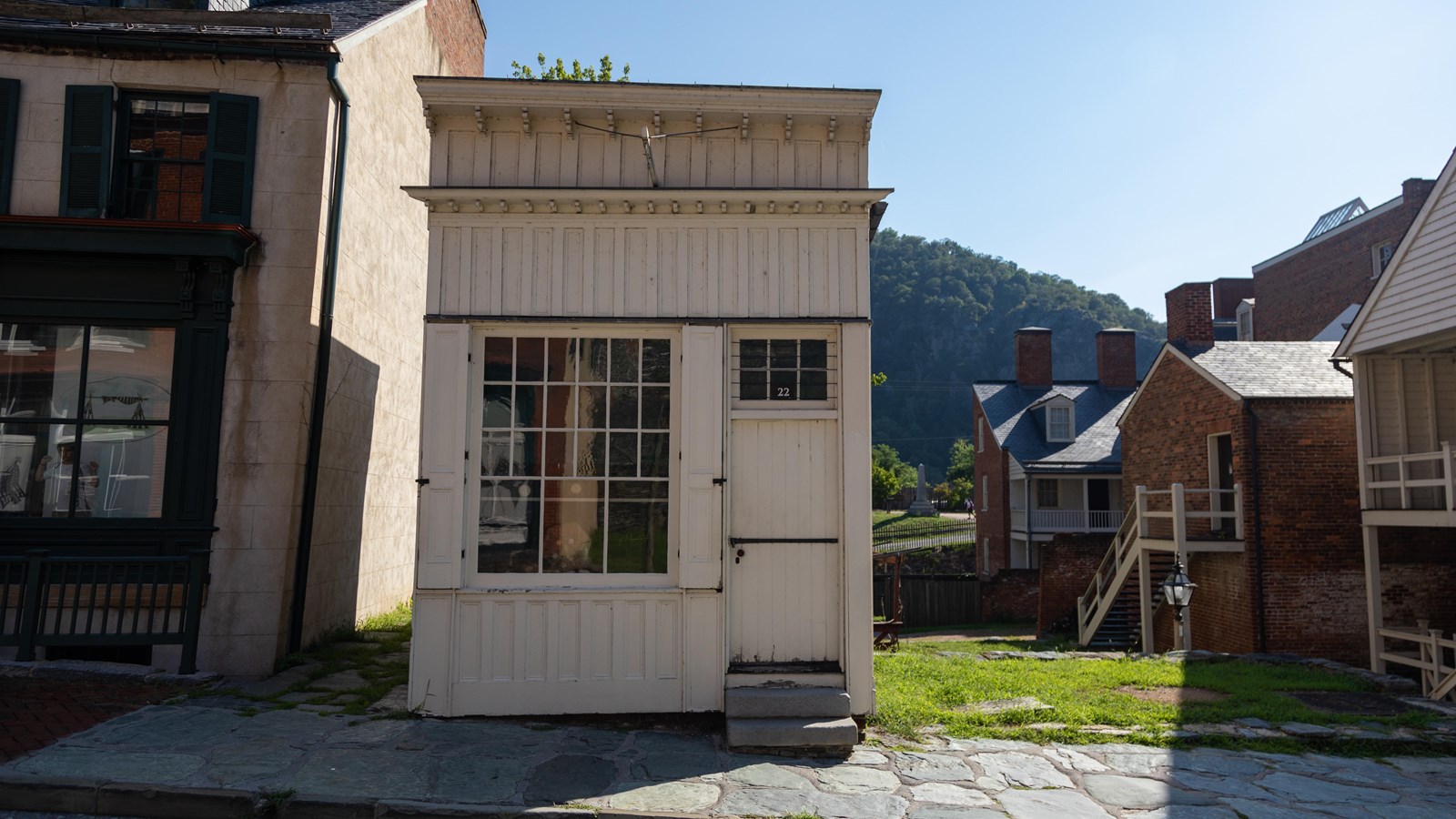 A small white shack with a large storefront window and door.