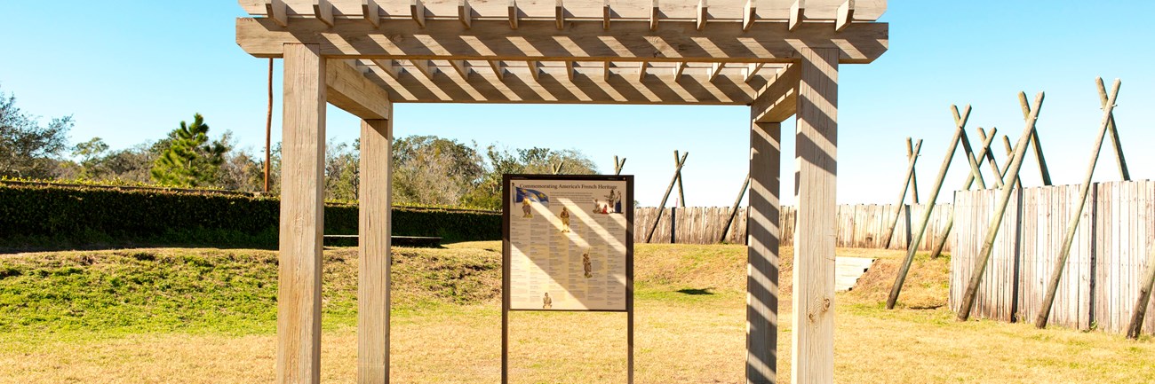 a pergola inside a fort with an exhibit panel listing names