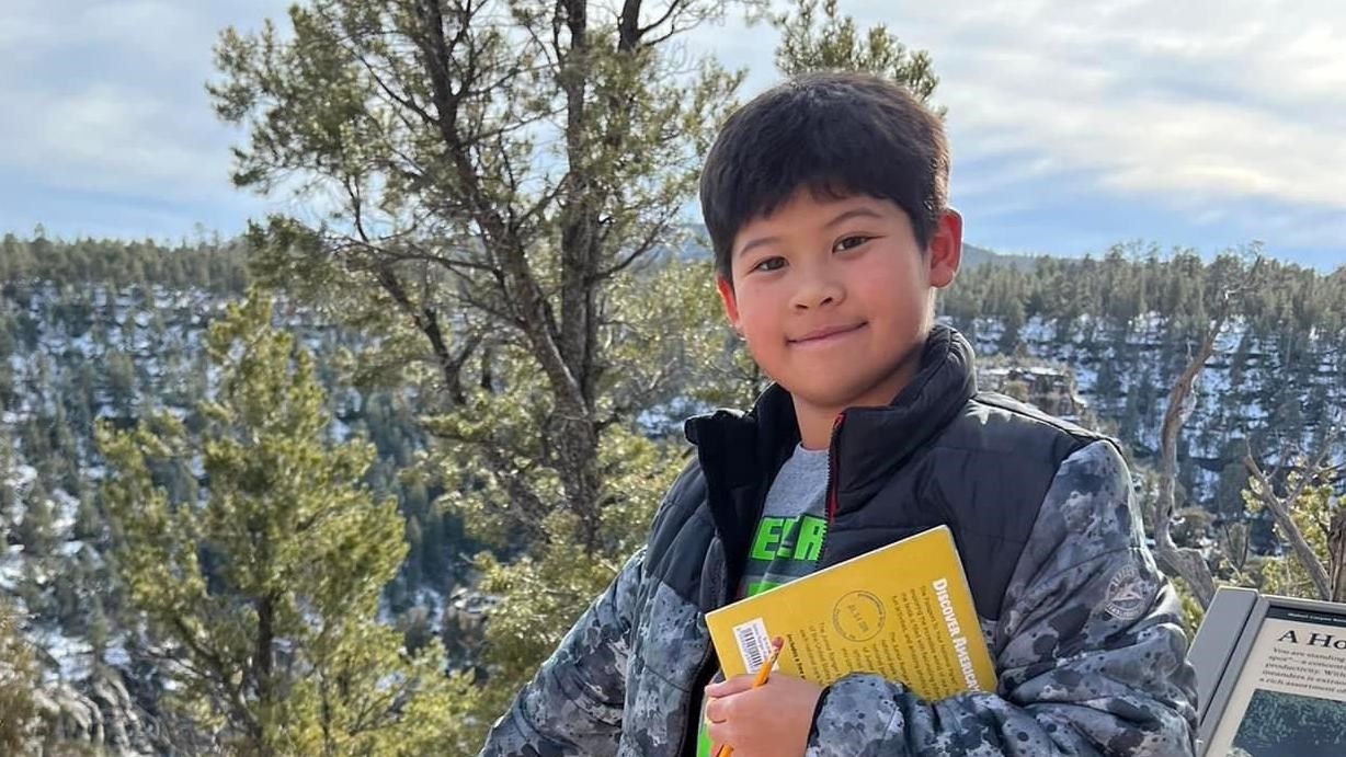 A child stands on a trail above Walnut Canyon.