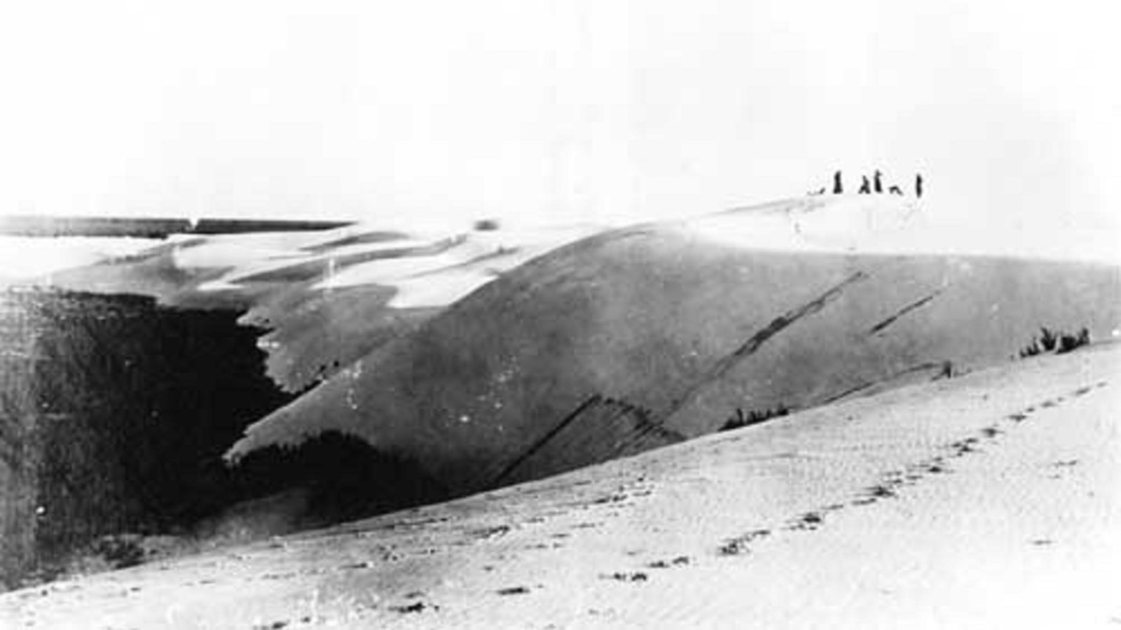 A grainy, black and white photo of visitors on the dunes at White Sands.