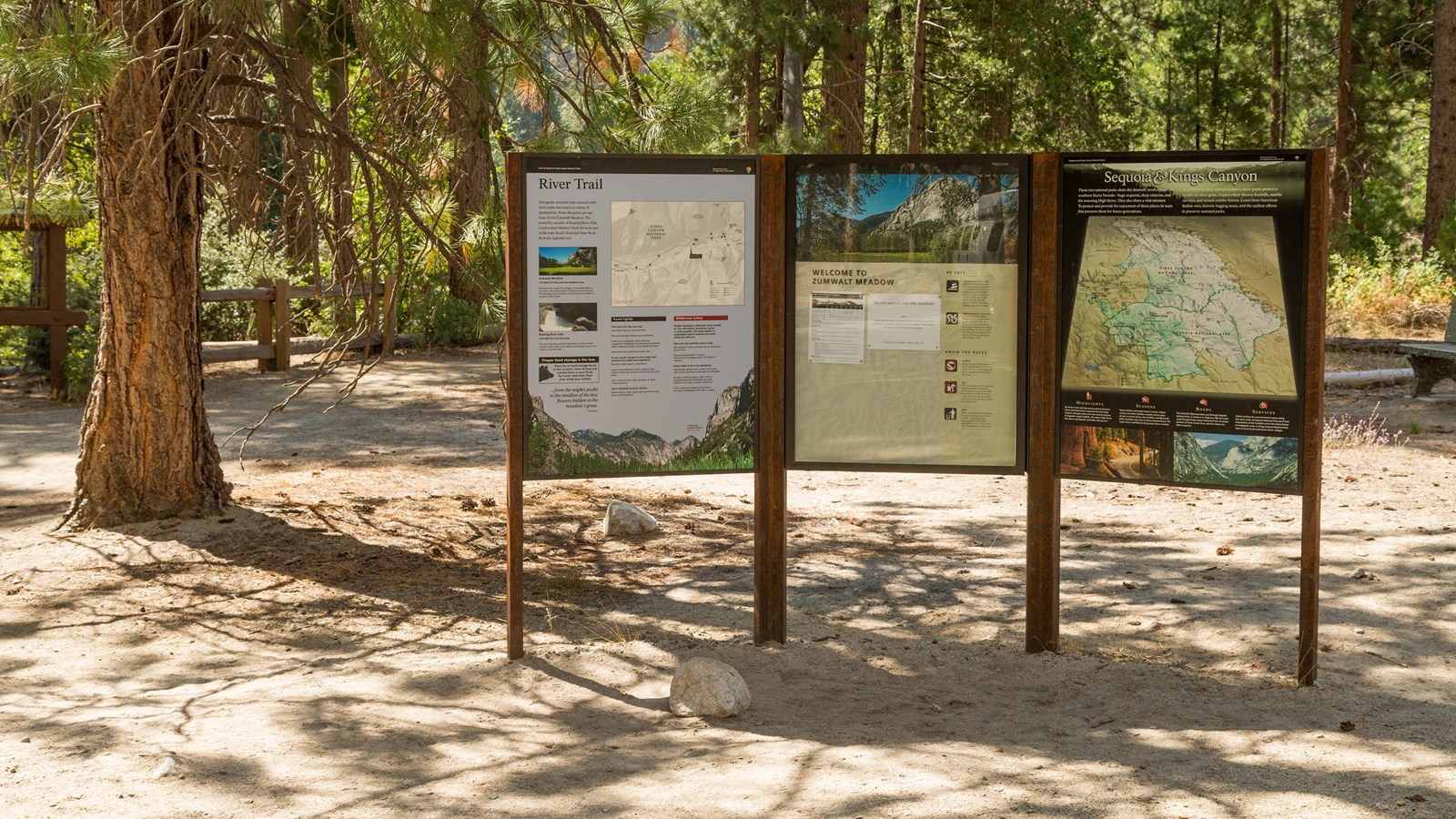 A tripanel board sits in a metal frame. On the board are images and text with information.