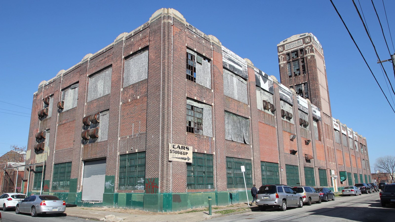 Three story brick factory building with boarded windows
