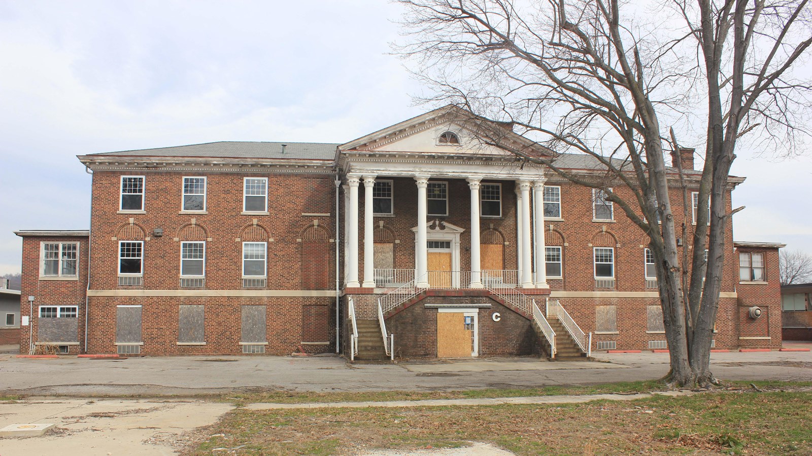 A three-story, eleven-bay brick building has a hipped slate roof.