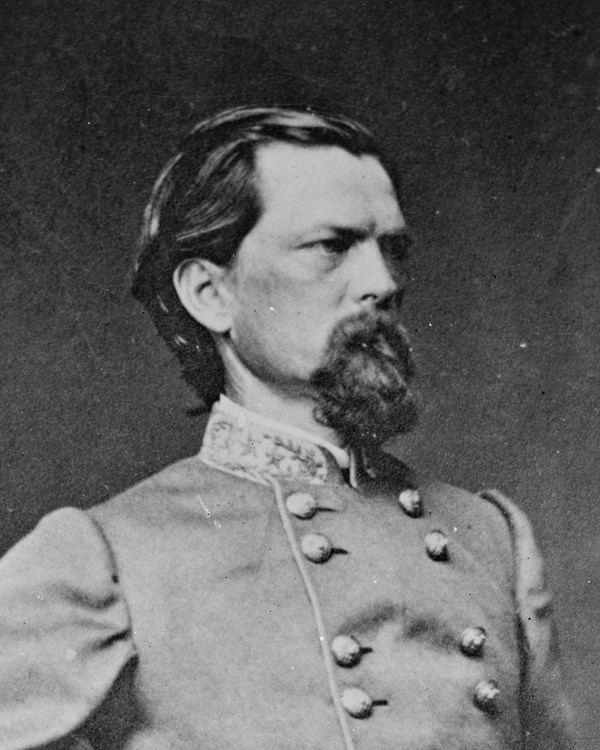 An 1860s standing portrait photo shows a thin bearded man in military officer's dress.