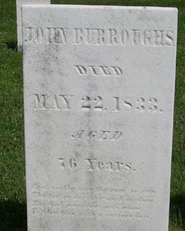 A white granite headstone with faded writing etched into it.
