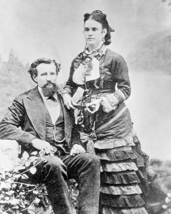 Black and white portrait of man and women in 1800's clothing.