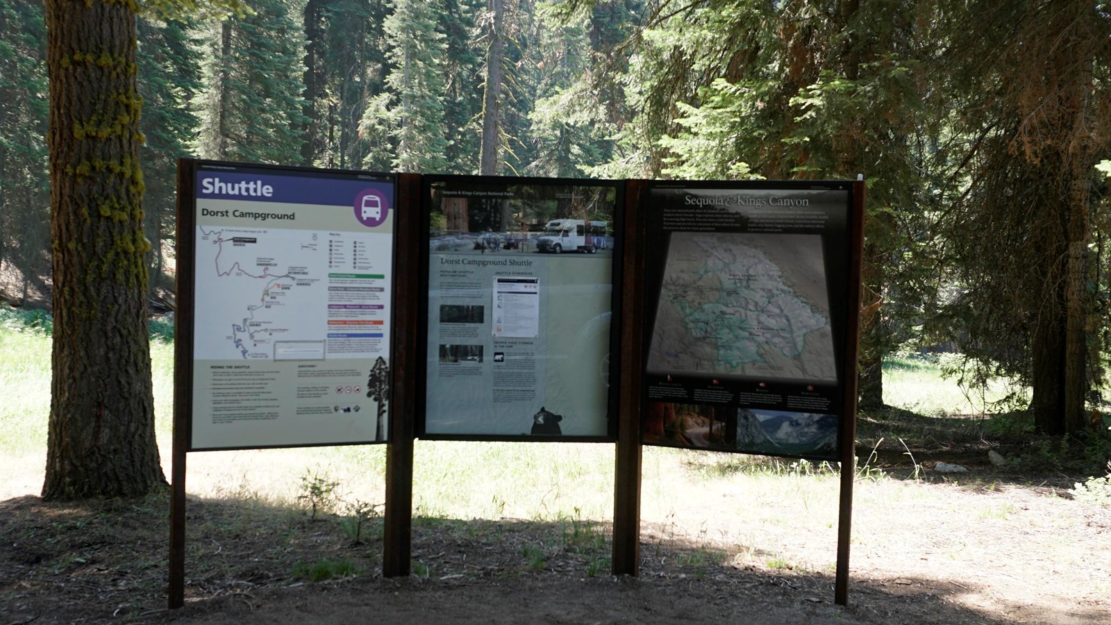 A black metal framed bulletin board has pieces of paper with text and images inside of it