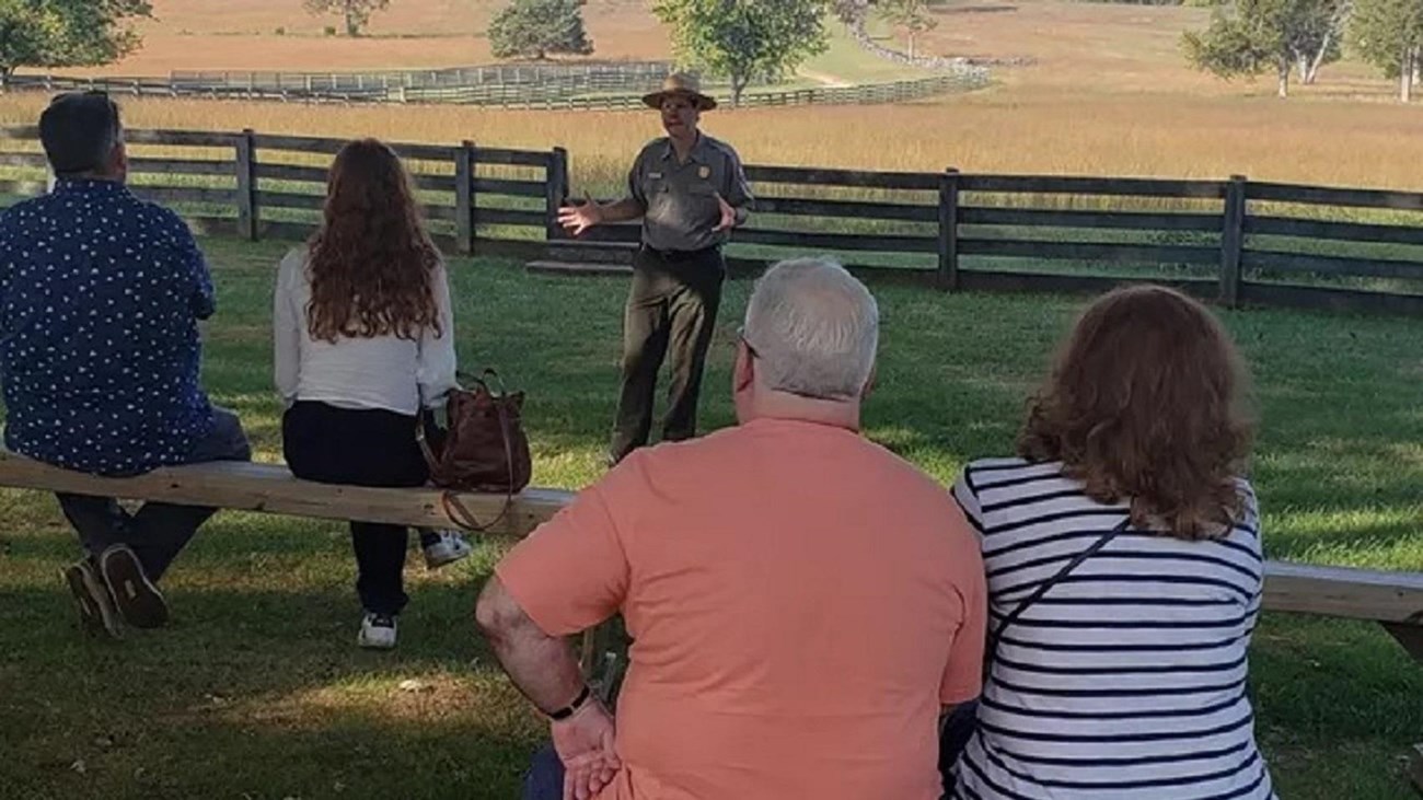 A ranger stands in front of a seated crowd.