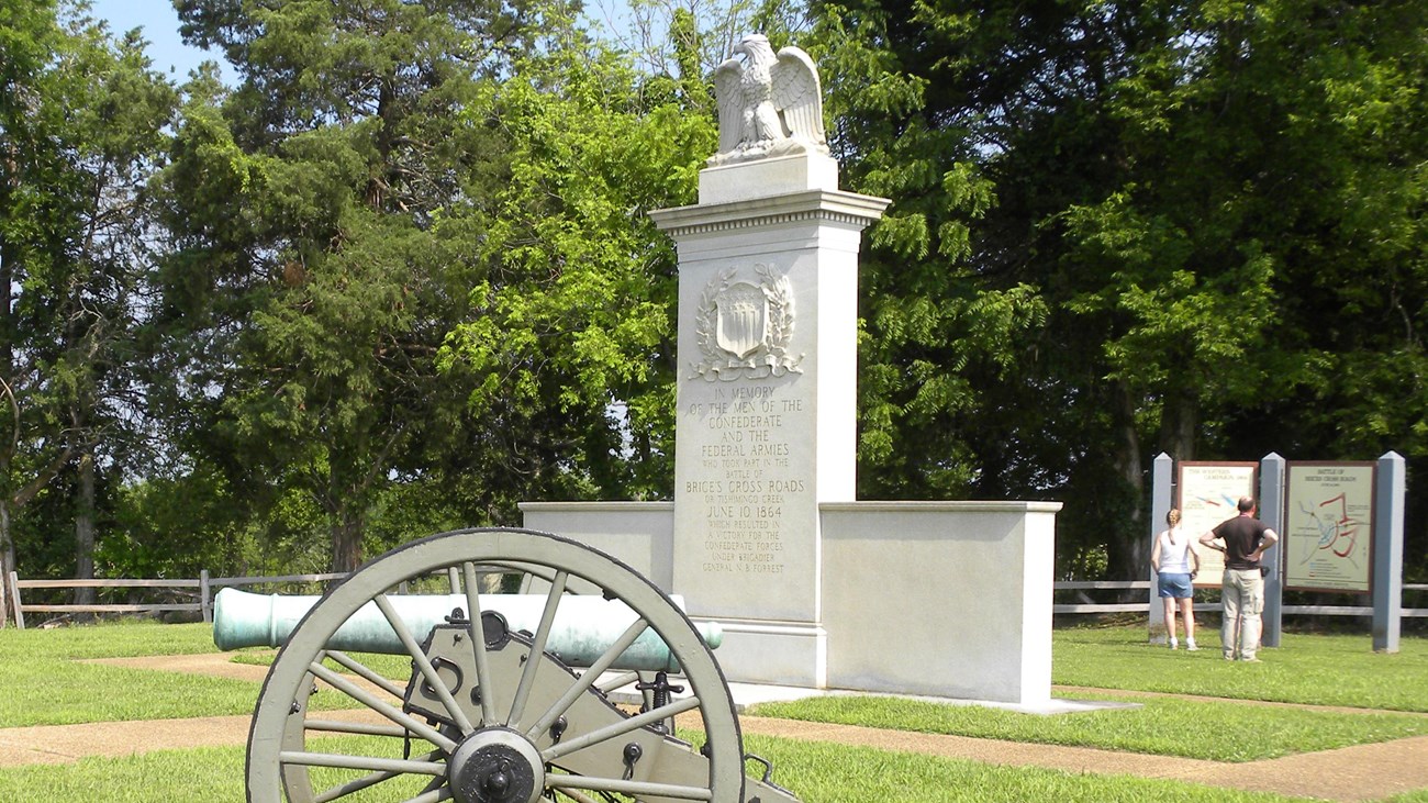 Brices Cross Roads National Battlefield Monument in middle with cannon in front.