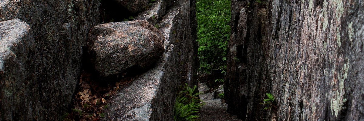 Rock bridge over a trail cut into granite