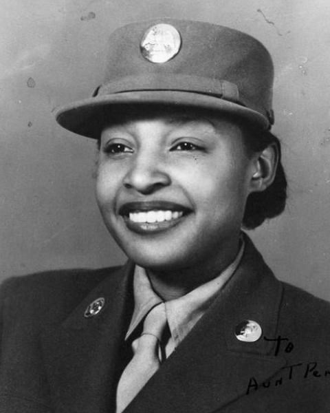 Black and white photo of African American women in 1940s WW2 uniform smiling at the camera.