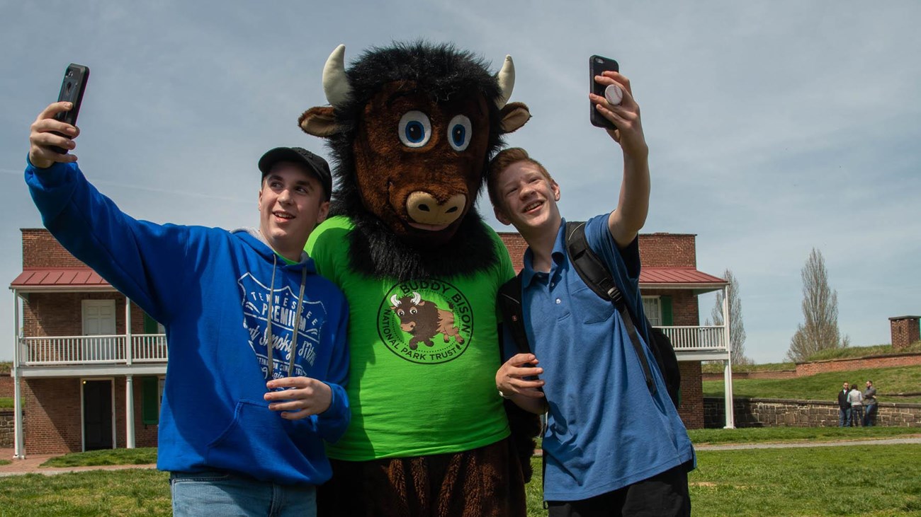 Visitors taking selfies with buddy bison.