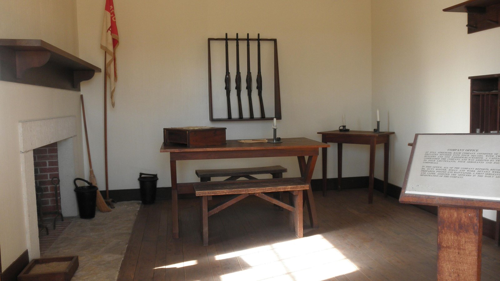 room with desks, a gun rack, and a flag