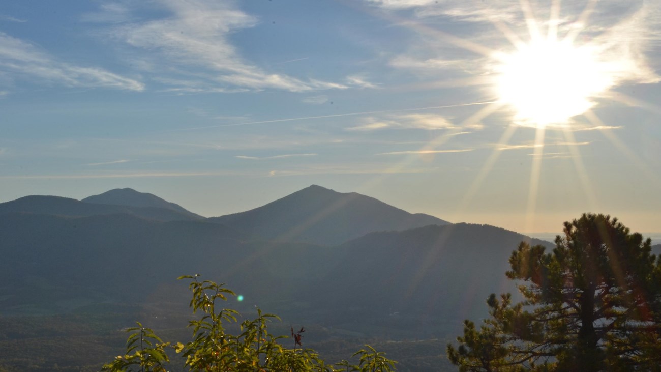 The sun rising over a mountains on a clear morning