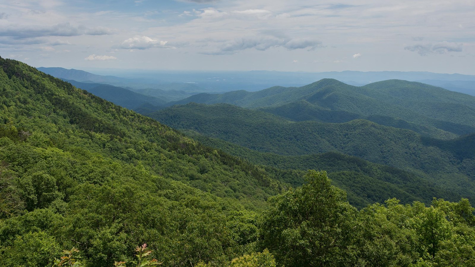 Green forested ridges and valleys stretch to the horizon