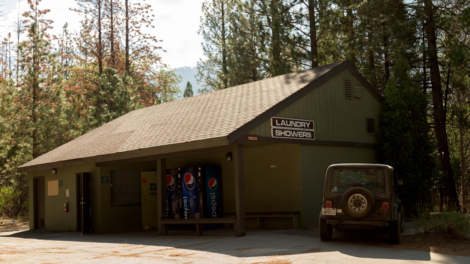 A small wooden green building houses the showers and laundry area of Cedar Grove.