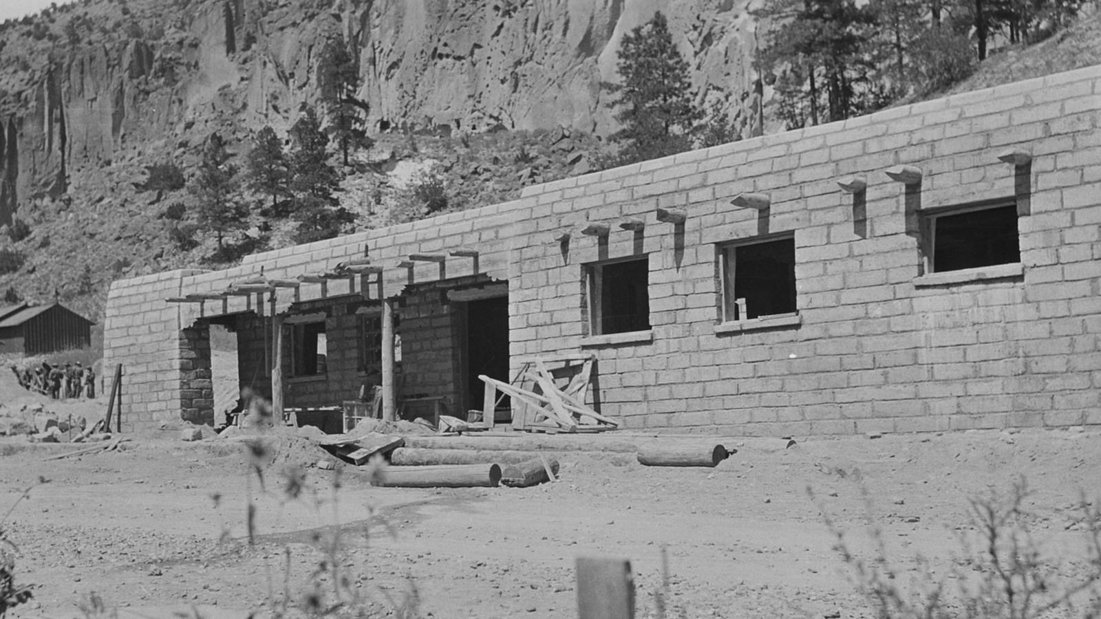 a stone building with 3 windows and a covered entrance is obviously under construction