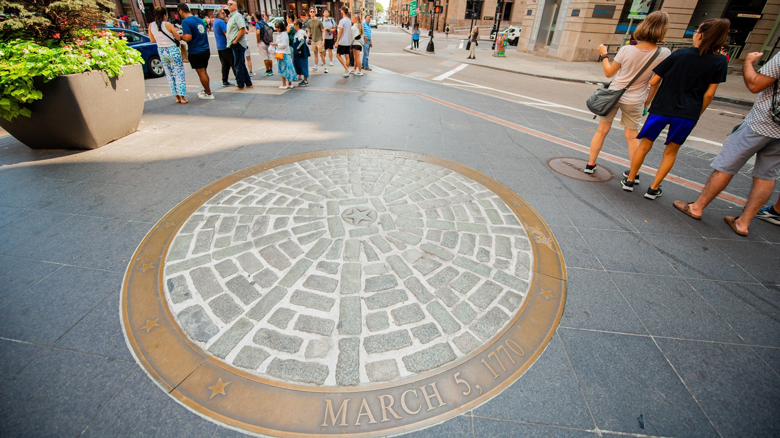 A bronze ring with stars and the date March 5, 1770 filled with granite pavers