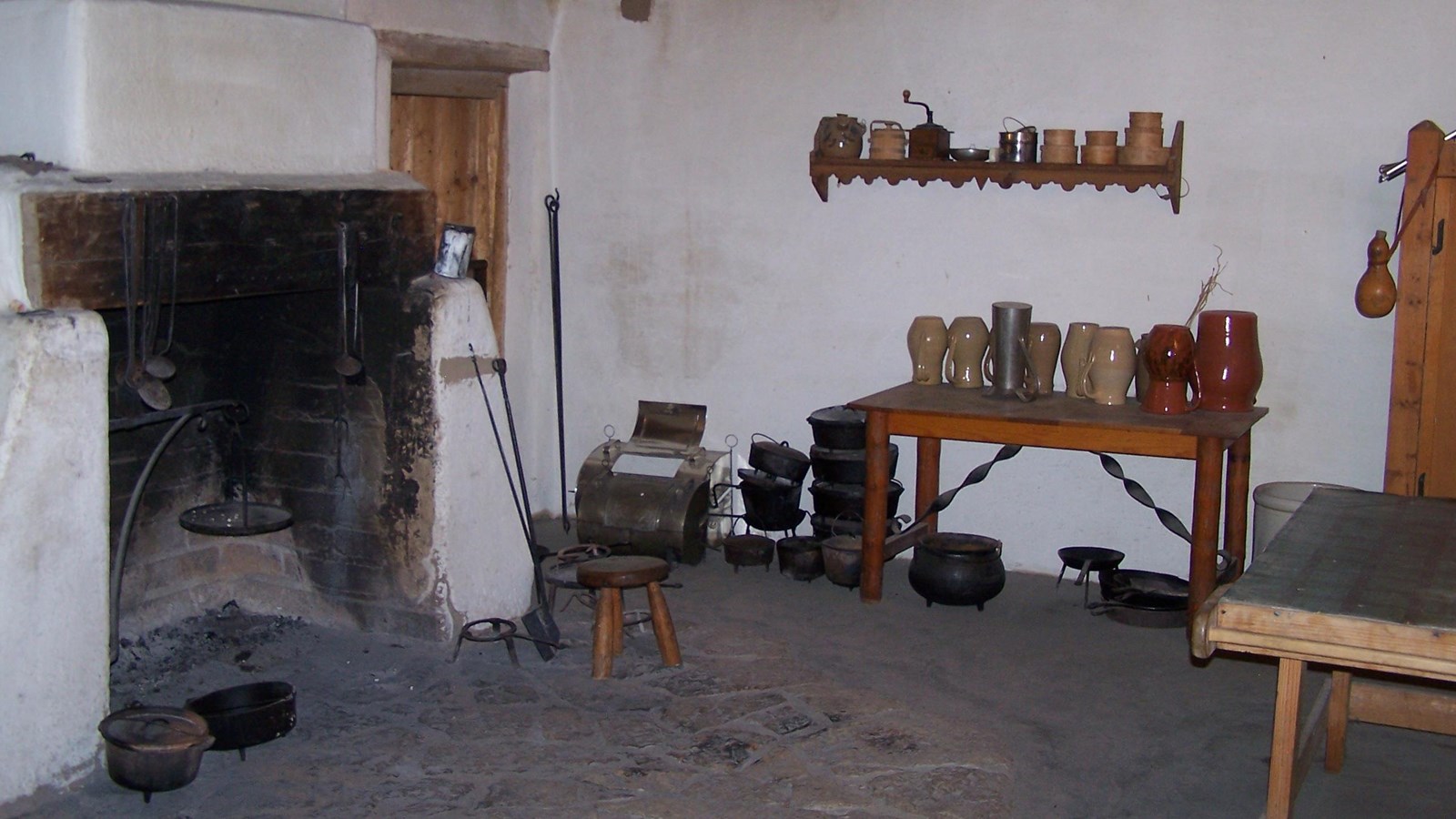 A massive fireplace dominates this room, with a stone hearth in front of it. 