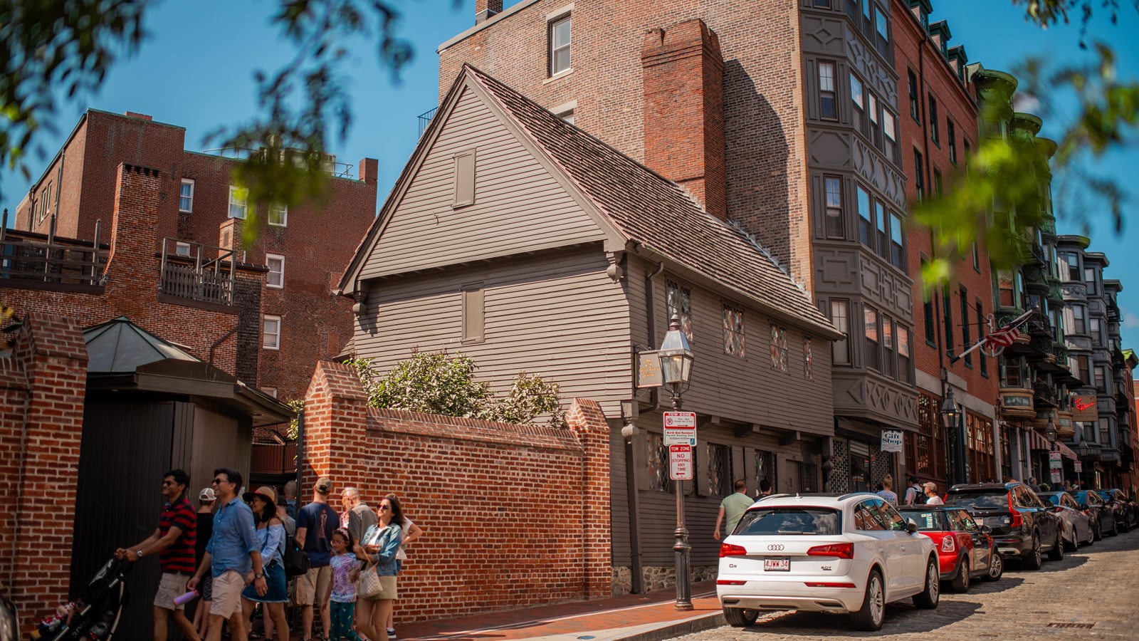 Photograph of a greenish grey clapboard house of two stories and a gable roof.