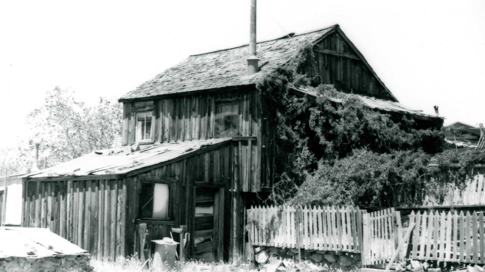 Wood-plank cabin bounded by a picket fence