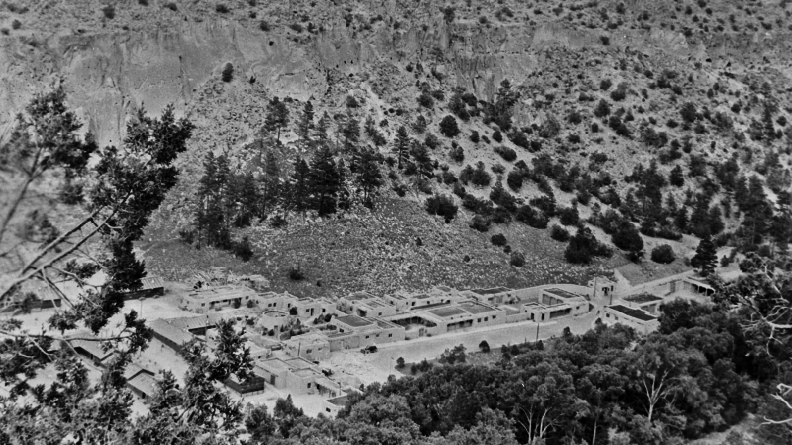 a bird\'s eye view of many stone buildings in the bottom of a canyon