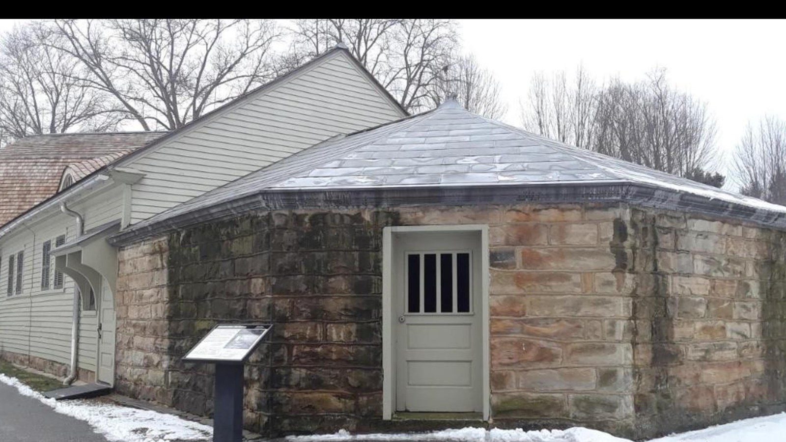 a stone building attached to another sided building